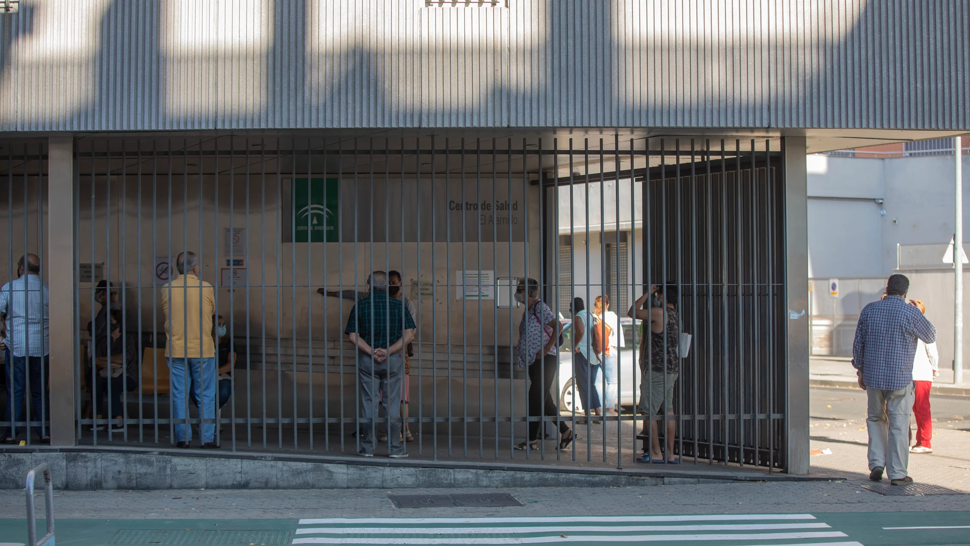 Usuarios guardan cola para recibir atención primaria en el centro de salud 'El Alamillo', en Sevilla