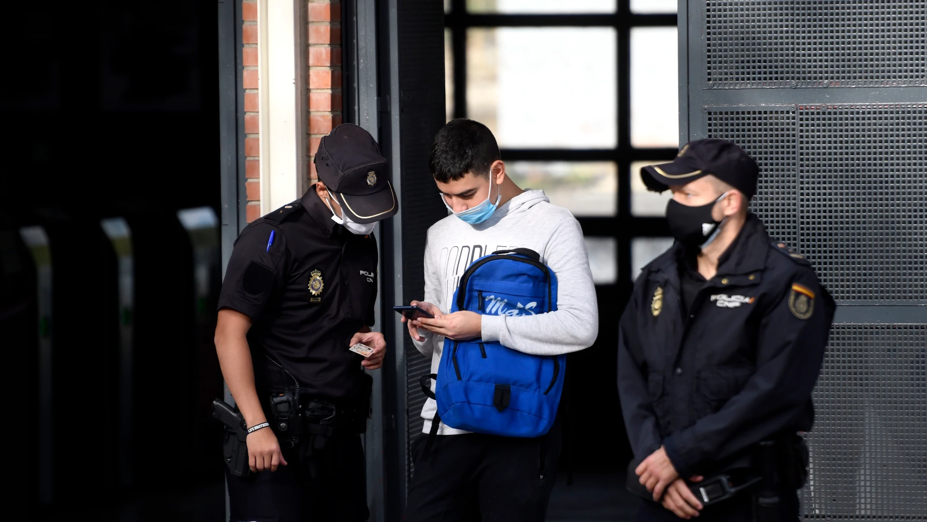 Agentes de la Policía Nacional realizan un control de movilidad en la estación de tren cercanías de Orcasitas, en el distrito de Usera