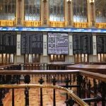 Varias pantalla muestran la evolución del IBEX 35 en el Palacio de la Bolsa en Madrid