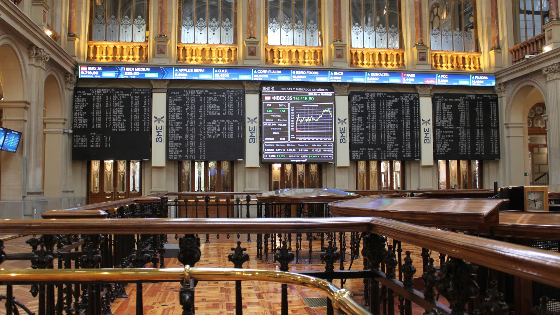 Varias pantalla muestran la evolución del IBEX 35 en el Palacio de la Bolsa en Madrid