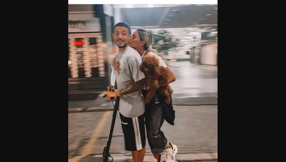Stefano Sensi y Giulia Amodio, subidos a un patinete eléctrico junto a un perro.