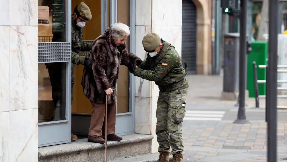 Dos militares del Ejército de Tierra ayudan a una mujer en Salamanca