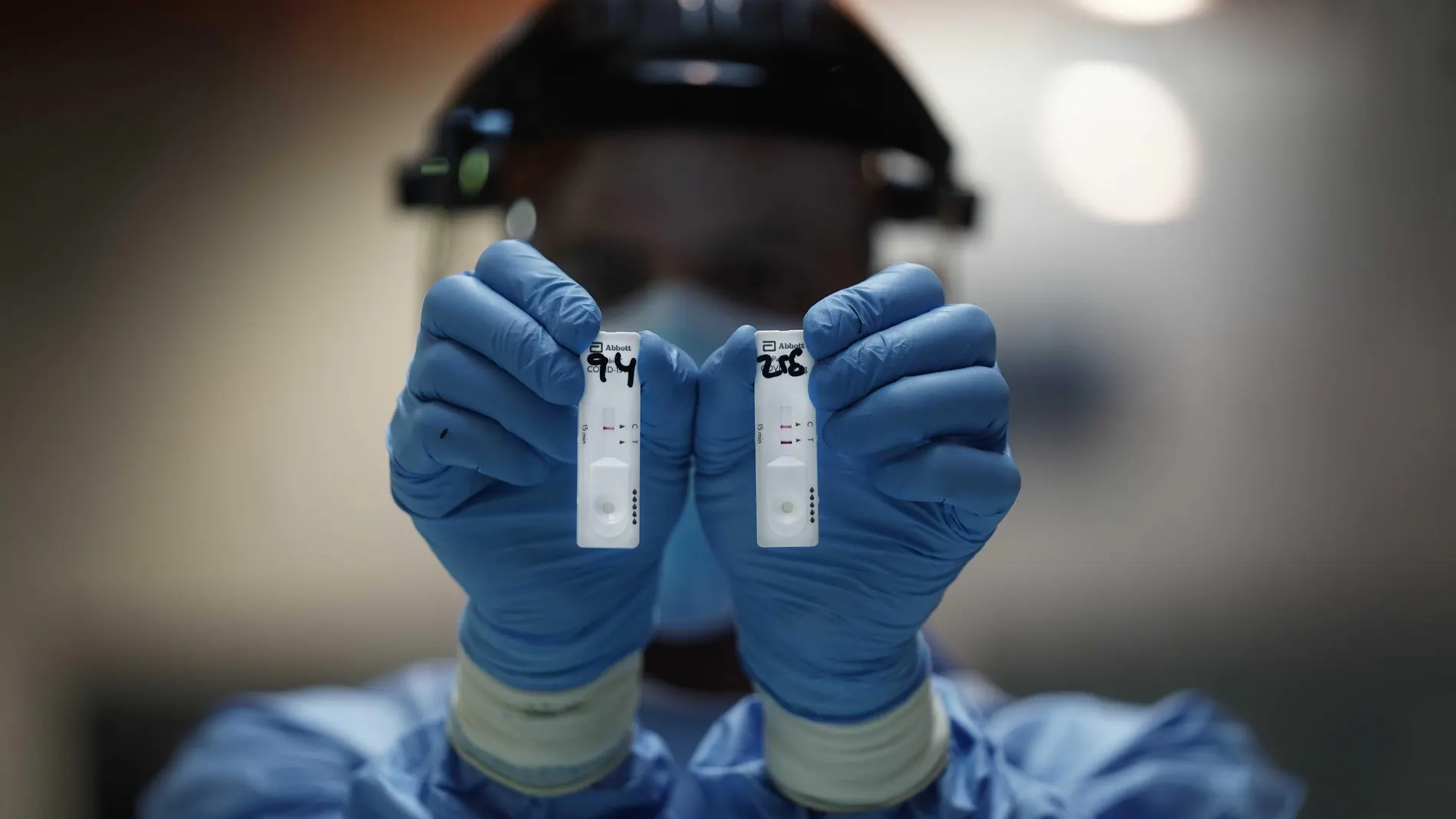 Un sanitario sostiene dos pruebas de test rápido de antígenos en la mano para la detección de la Covid