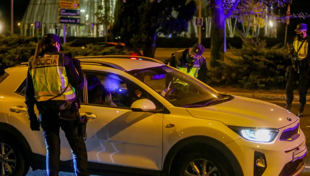 Dos policías nacionales paran a un coche en un control policial en el Paseo de la Castellana de Madrid, incorporación al nudo de manoteras, la noche del 2 de octubre del 2020. Las medidas de restricción del Gobierno central que afectan a municipios madrileños con alta incidencia de coronavirus han entrado en vigor a las 22 horas de esta noche. Los municipios que se ven afectados por estas nuevas restricciones son Madrid, Alcalá de Henares, Alcobendas, Alcorcón, Fuenlabrada, Getafe, Leganés, Móstoles, Parla y Torrejón de Ardoz.02 OCTUBRE 2020Ricardo Rubio / Europa Press02/10/2020