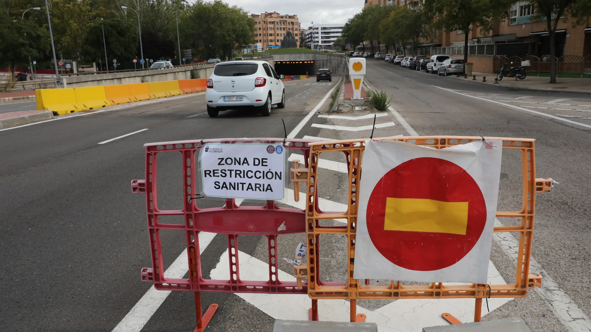 Un coche pasa junto a un cartel que indica que accede a una zona de restricción sanitaria.