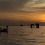 Un grupo de pescadores pasa frente a una estructura petrolera descompuesta en el Lago de Maracaibo (Venezuela). Venezuela