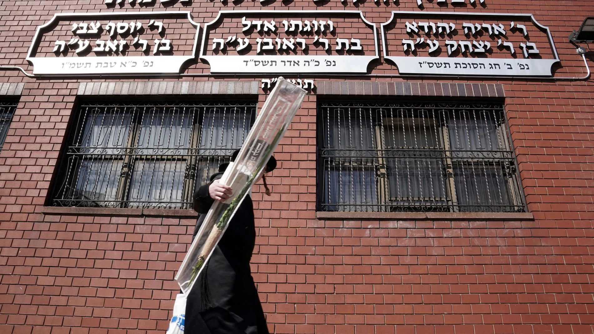 Un judío ultraortodoxo pasa frente a una escuela cerrada por la pandemia en Brooklyn