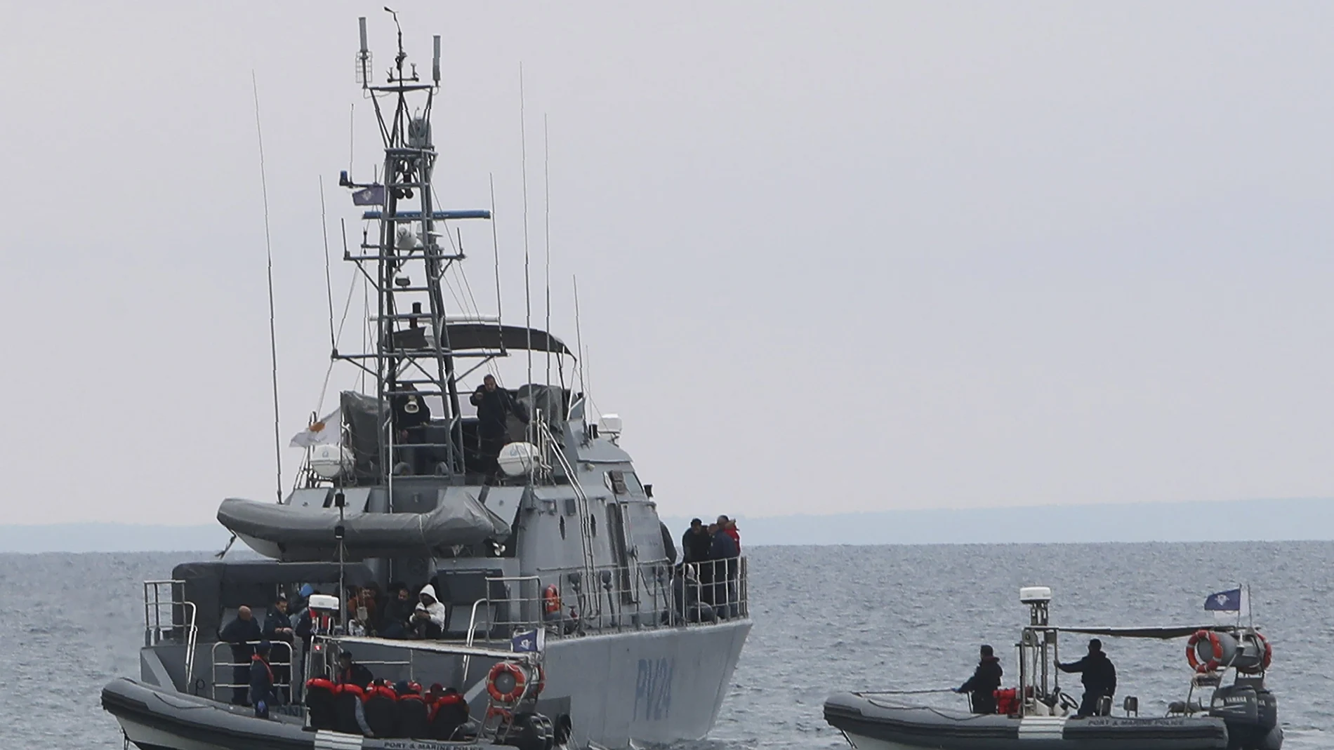 Migrantes a bordo de un bote patrullero de la Policía Naval chipriota son trasladados al puerto tras ser rescatados de un barco cerca de Protaras