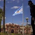 Un hombre con mascarilla camina junto a la Casa Rosada, el palacio presidencial, en Buenos Aires