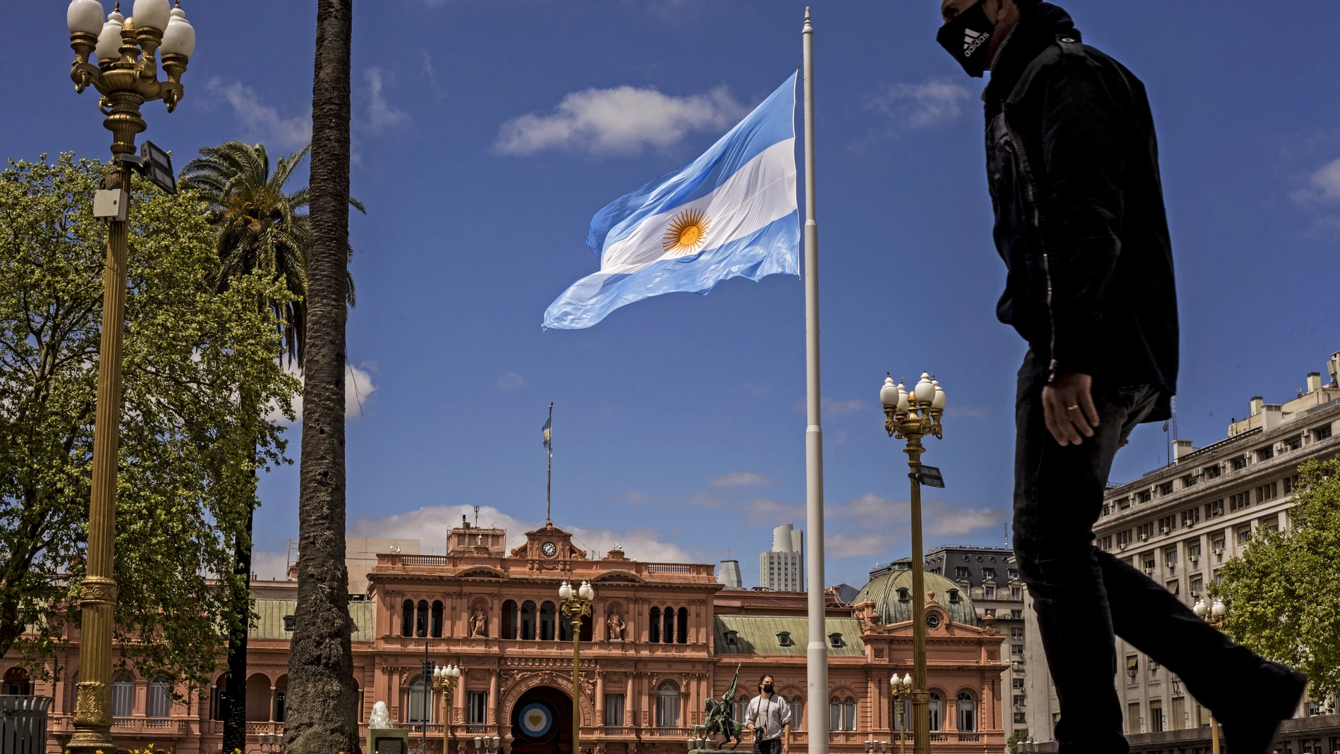 Un hombre con mascarilla camina junto a la Casa Rosada, el palacio presidencial, en Buenos Aires