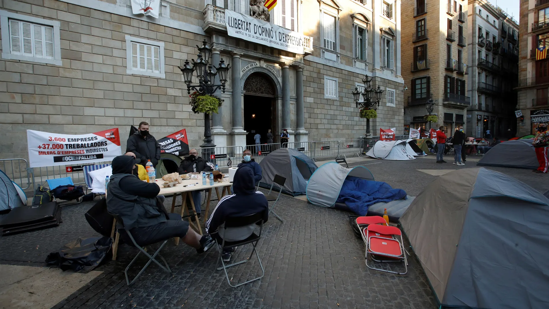 Trabajadores y empresarios del sector del ocio nocturno de Cataluña siguen acampados en la plaza de Sant Jaume de Barcelona en protesta por las medidas decretadas por el Govern de la Generalitat y por el Gobierno español que restringen la abertura de discotecas y bares musicales por el efecto de la pandemia de coronavirus. EFE/ Toni Albir