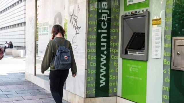 Una mujer pasa delante de una sucursal de la entidad Unicaja Banc