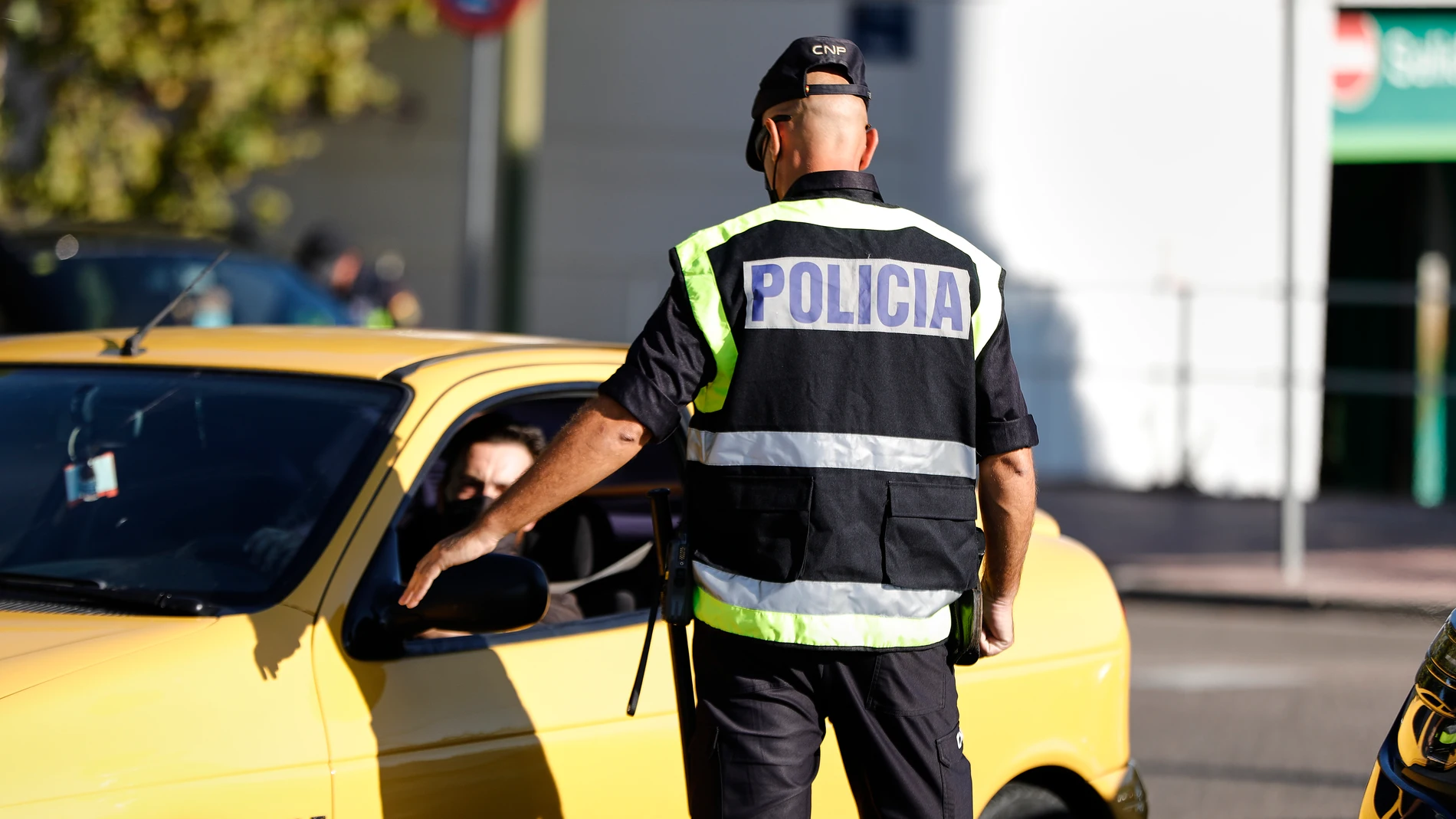Un agente de la Policía Nacional habla con un conductor durante un control policial en una calle de Móstoles, Madrid
