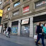 Peatones pasan al lado de locales cerrados en la Gran Vía madrileña