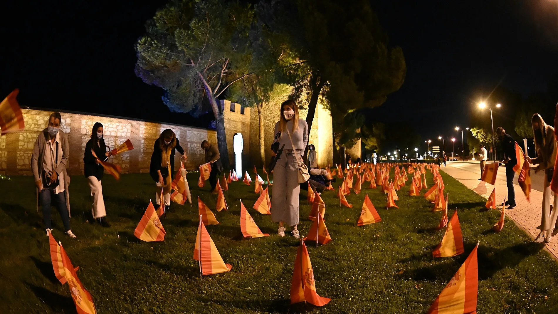 Miembros de la Asociación Española de Víctimas del Coronavirus colocan ayer jueves frente a la Muralla de Alcalá 1500 banderas de España como homenaje a las víctimas de la pandemia