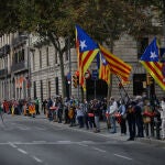Manifestantes sostienen banderas independentistas en la cadena humana formada como signo de protesta por la visita del Rey a Barcelona.