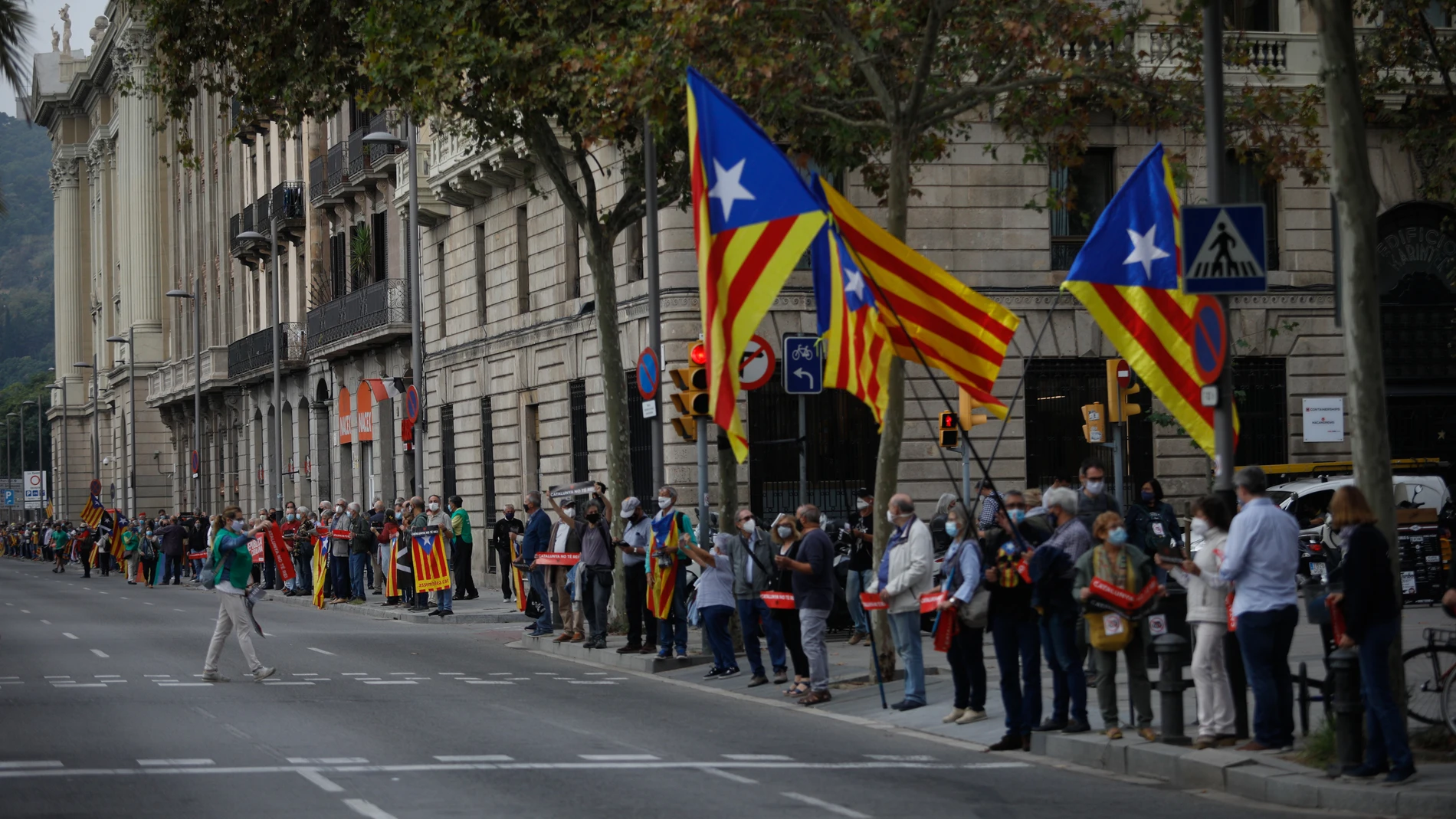 Manifestantes sostienen banderas independentistas en la cadena humana formada como signo de protesta por la visita del Rey a Barcelona.