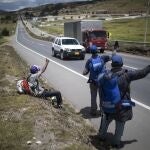 Venezuelan migrants hitchhike towards the capital, in Tunja, Colombia, Tuesday, Oct. 6, 2020. Amid COVID-19, drivers are more reluctant to pick up hitchhikers, shelters remain closed, and locals who fear contagion are less likely to help out with food donations. (AP Photo/Ivan Valencia)