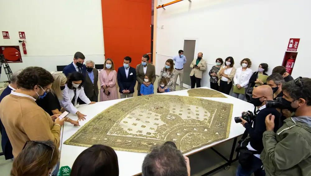 La consejera de Cultura y Patrimonio Histórico, Patricia del Pozo (3i), acompañada de diversas personas y medios de comunicación observa el conjunto textil "de los Apóstoles" de la Virgen del Rocío que han recibido para su restauración en el Instituto Andaluz de Patrimonio Histórico (IAPH) en Sevilla.