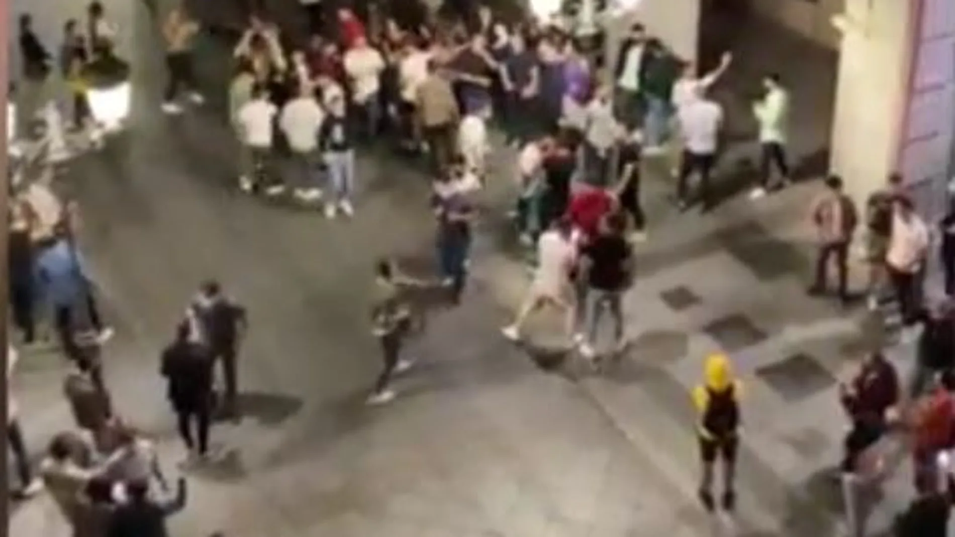 Jóvenes en la calle de Granada sin mantener la distancia de seguridad ni mascarillas