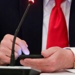 Donald Trump usa su móvil durante un encuentro en la Casa Blanca