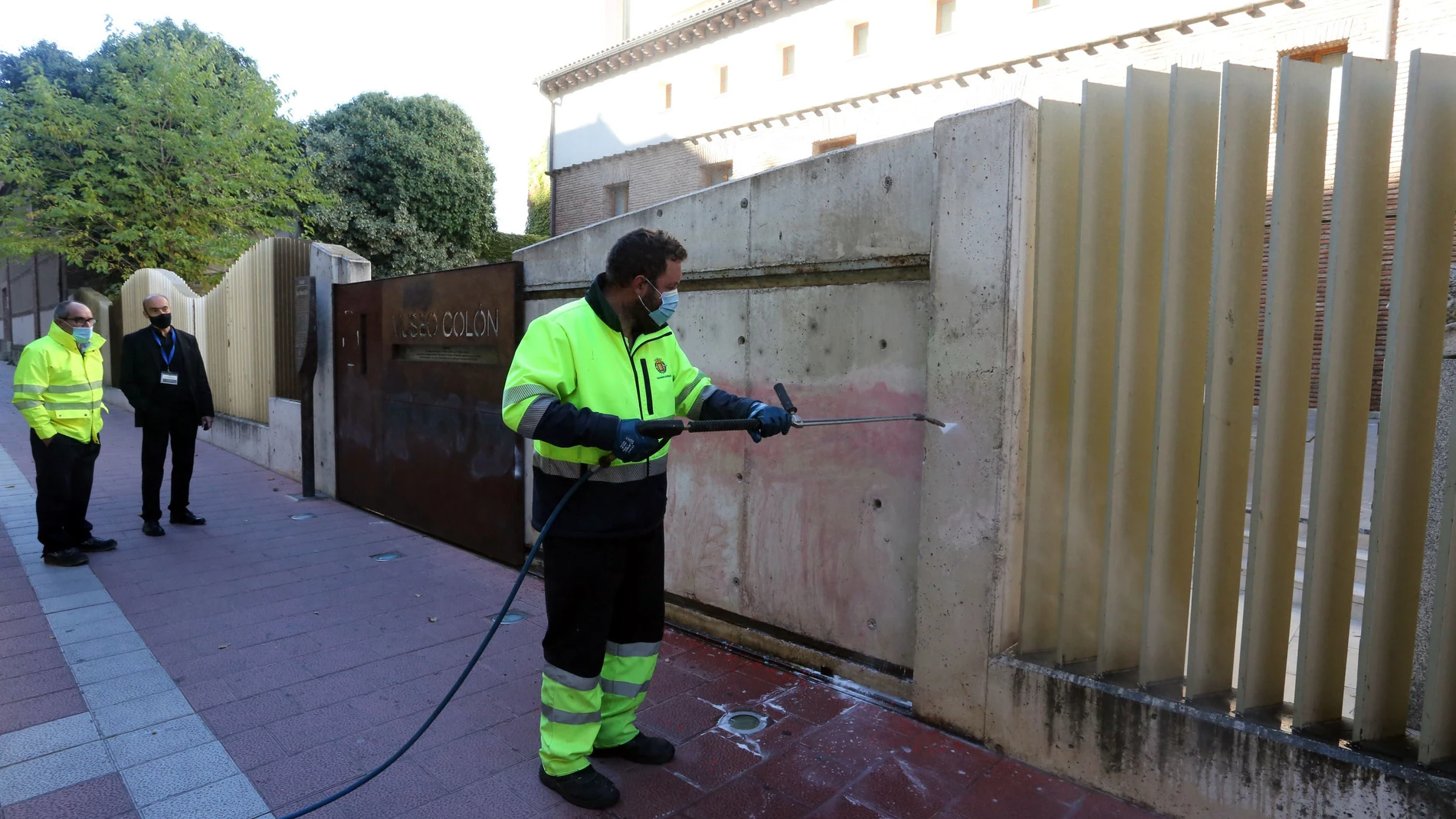 Operarios limpian las pintadas contra el Día de la Hispanidad en la Casa de Colón de Valladolid