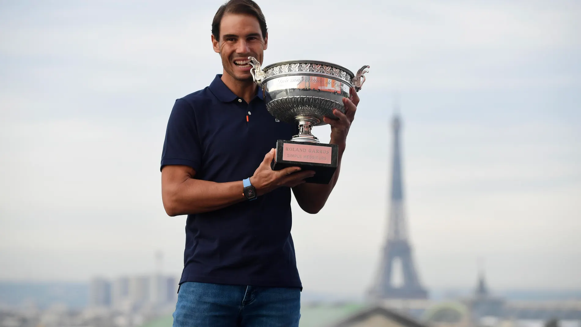 Rafa Nadal posa con el trofeo de campeón de Roland Garros 2020 con la Torre Eiffel al fondo.