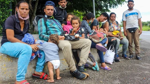 Familias de migrantes venezolanos descansan en una acera el 30 de septiembre de 2020, en San Cristóbal, estado Táchira (Venezuela)
