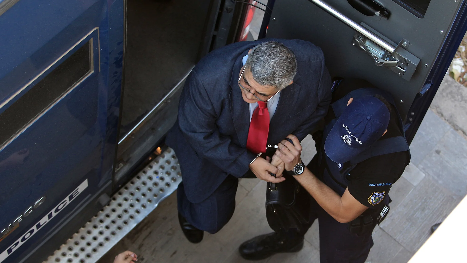 El líder del partido ultra Amanecer Dorado, Nikos Michaloliakos, es escoltado a la corte, en Atenas, en una foto de archivo