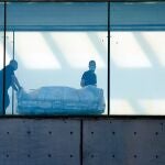 Dos celadores transportan una camilla en el Hospital de Bellvitge