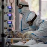 Dos enfermeras del hospital Virgen de la Arrixaca de Murcia atienden a una enferma de covid 19 en la UCI