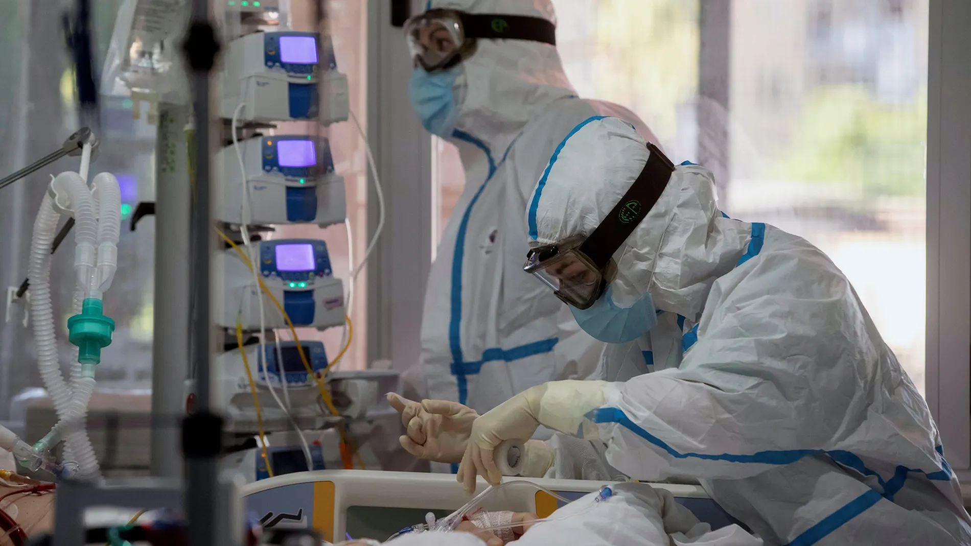 Dos enfermeras del hospital Virgen de la Arrixaca de Murcia atienden a una enferma de covid 19 en la UCI