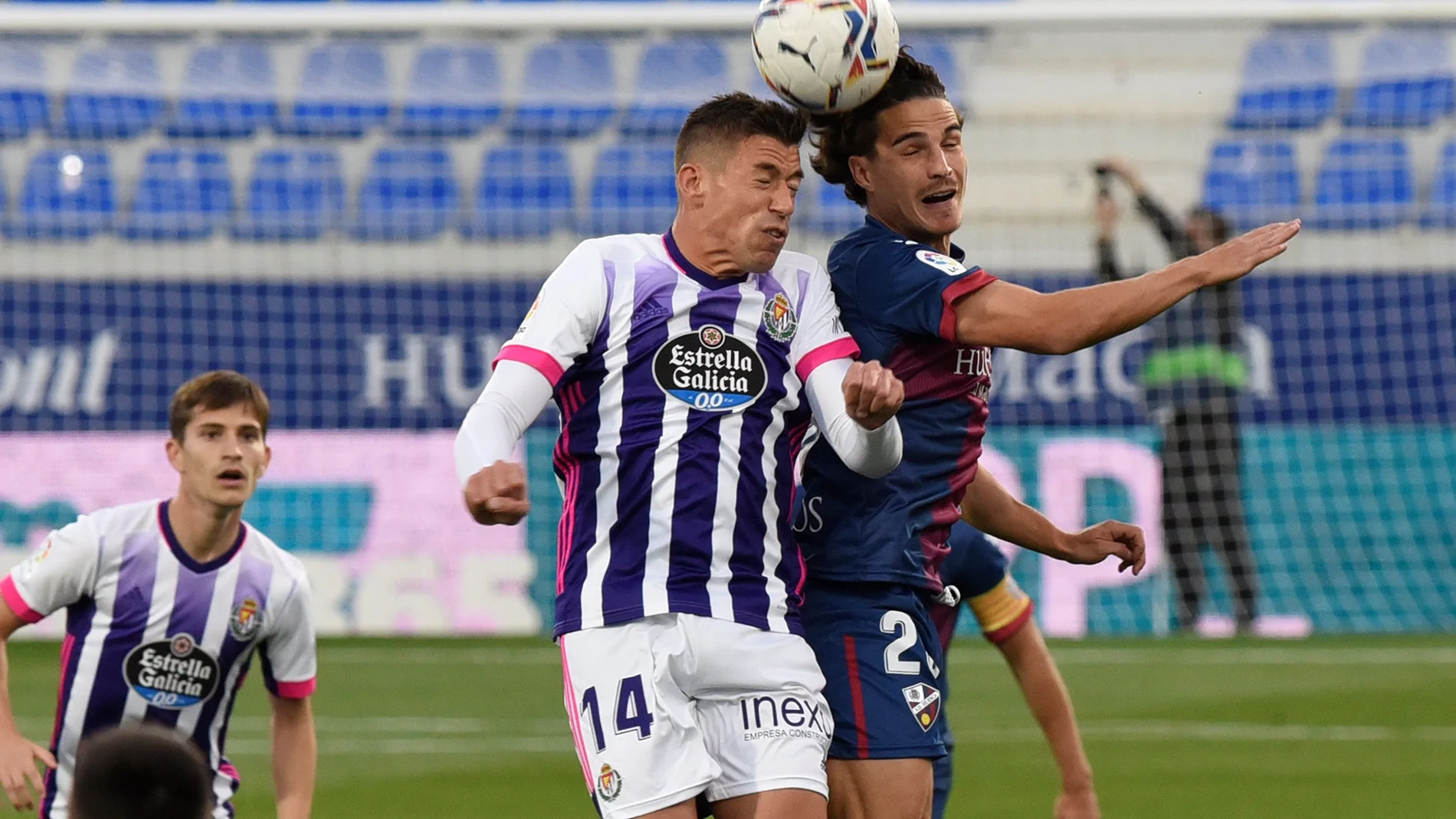 El centrocampista del Huesca Jaime Seoane (d) salta a por un balón con Rubén Alcaraz (c), del Valladolid, durante el partido de Liga en Primera División que disputan este domingo en el estadio de El Alcoraz, en Huesca. EFE/Javier Blasco