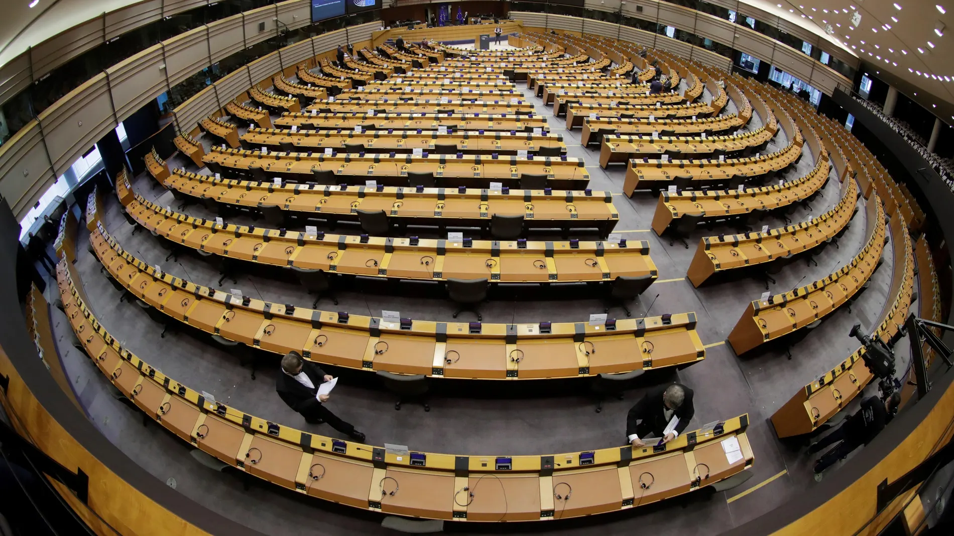 Varios empleados del Parlamento Europeo apuntalan los últimos detalles del hemiciclo antes de una sesión plenaria en Bélgica