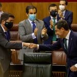 El presidente andaluz, Juanma Moreno, choca su puño con el del vicepresidente y socio de Gobierno de Ciudadanos, Juan Marín