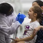 Una sanitaria realiza una prueba de coronavirus a una niña en Israel