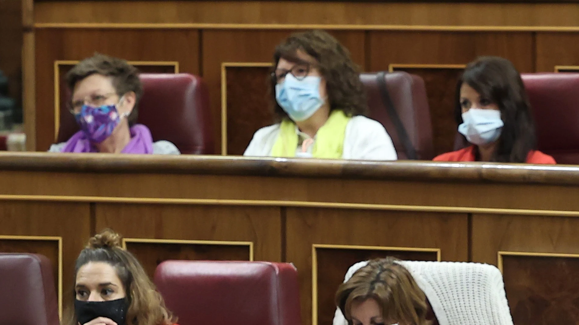 La diputada de Unidas Podemos por Islas Baleares, Antonia Jover, la valenciana Rosa Medel y la diputada por Andalucía Martina Valverde, ataviadas de un fular morado, otro amarillo y una chaqueta roja, imitan los colores de la bandera tricolor