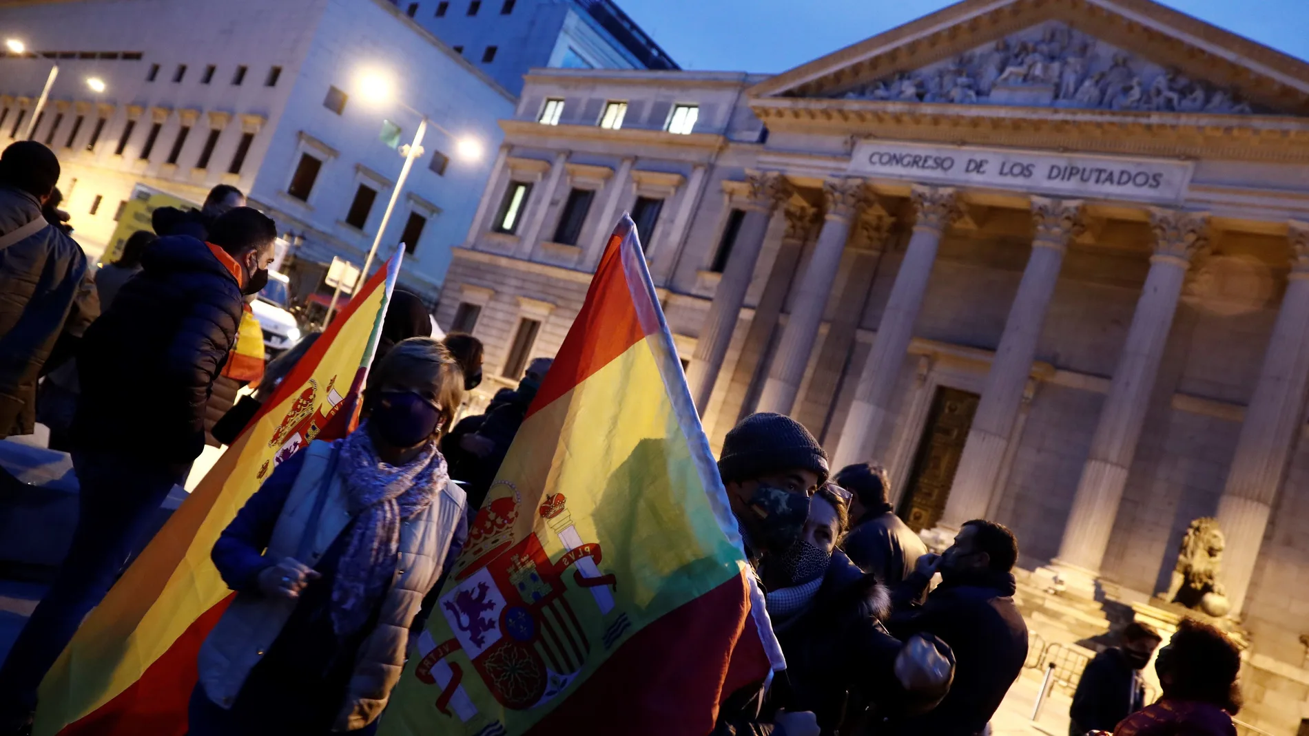 Varios ciudadanos se concentran ante el Congreso de los Diputados con banderas de España, este miércoles, antes de que Vox presente la moción de censura contra el Gobierno de Pedro Sánchez en la Cámara Baja. EFE/Mariscal