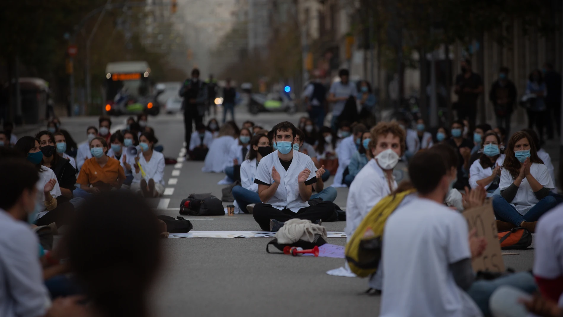 Profesionales sanitarios se sientan en el suelo de la Calle de Balmes con Gran Vía de les Corts Catalanes en una concentración de Médicos Internos Residentes (MIR) en Barcelona, en una imagen de archivo