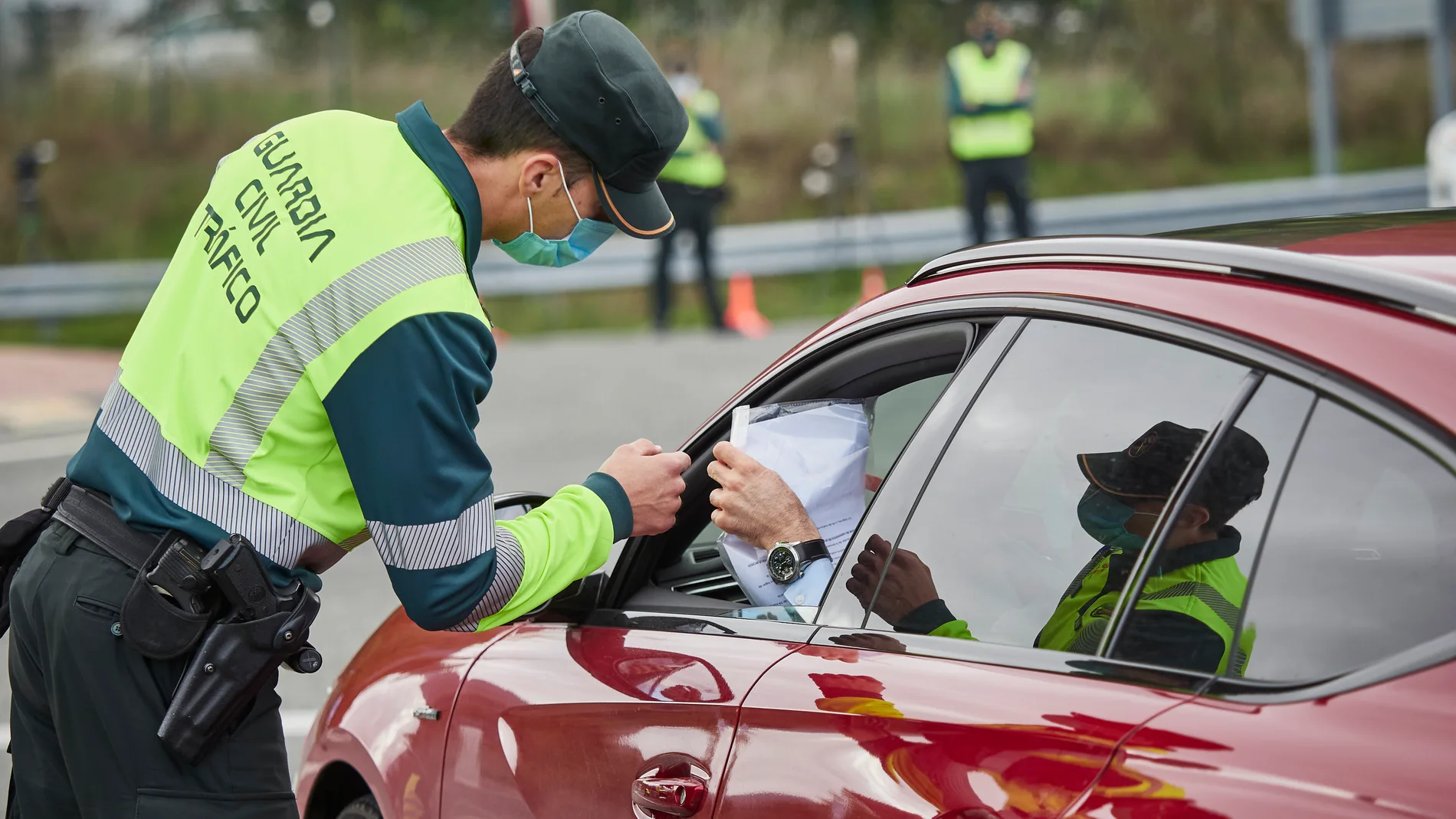 Un conductor entrega un justificante a un Guardia Civil que le permitiría moverse entre dos territorios con restricciones
