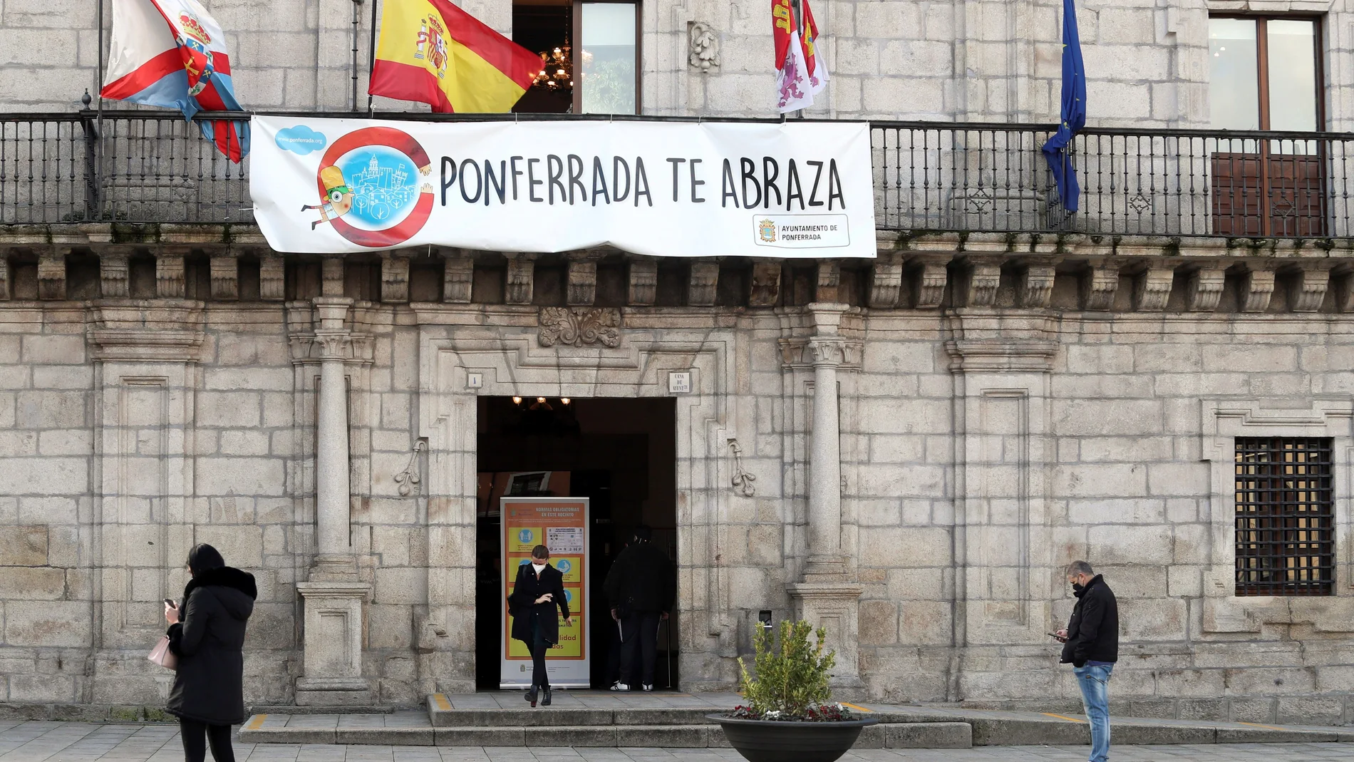 Varias personas pasan junto al ayuntamiento de Ponferrada