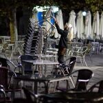 Una camarera recoge la terraza de un bar en Valladolid momentos antes del inicio del toque de queda impuesto por la Junta de Castilla y León debido al alto número de contagios de coronavirus en la Comunidad. EFE/NACHO GALLEGO