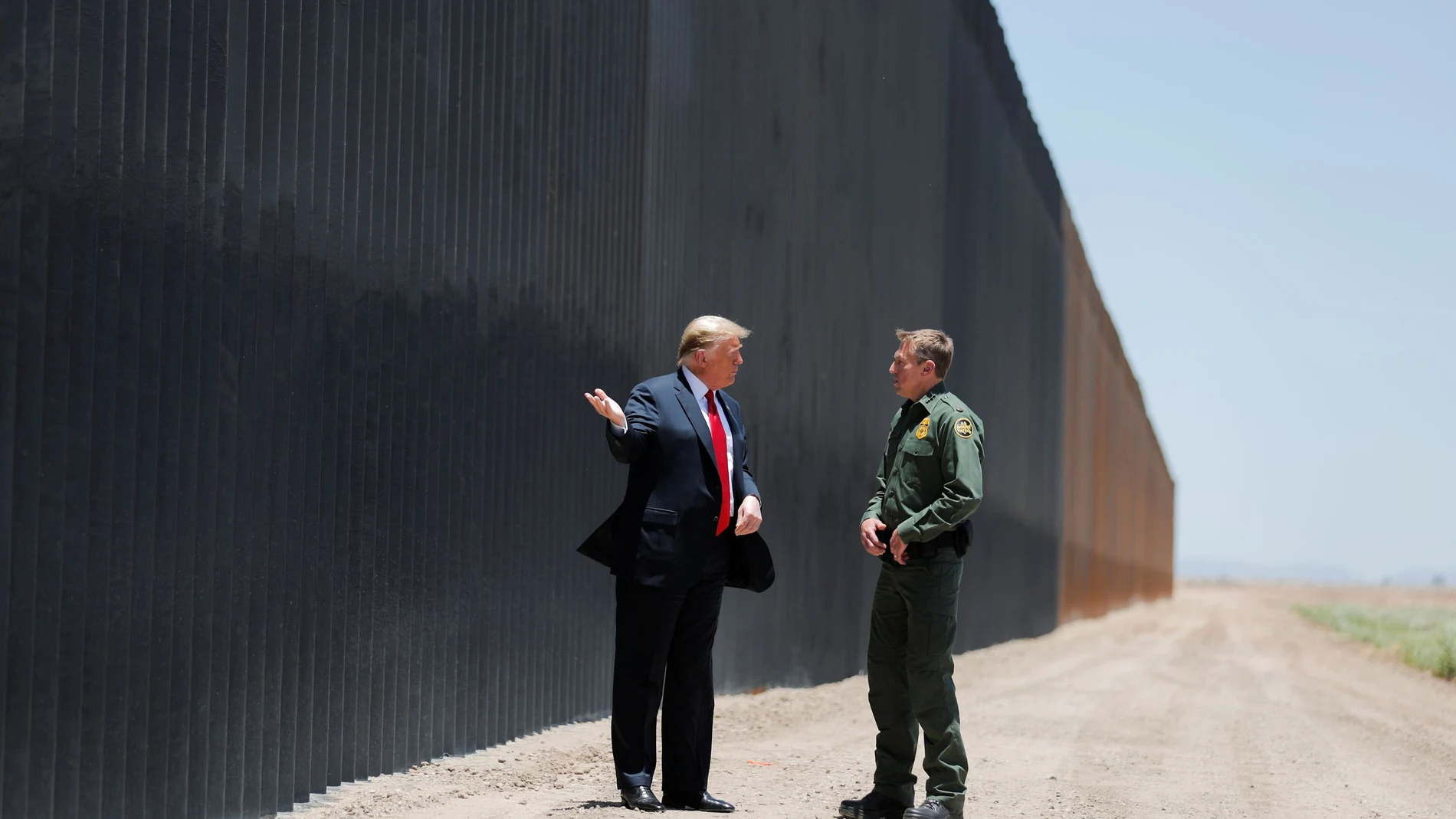 Donald Trump conversa con el jefe de la patrulla policial Rodney Scott durante una visita a la frontera.