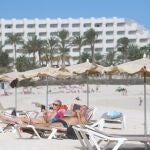 Varios turistas disfrutan del sol en la playa del municipio de Corralejo (Fuerteventura)