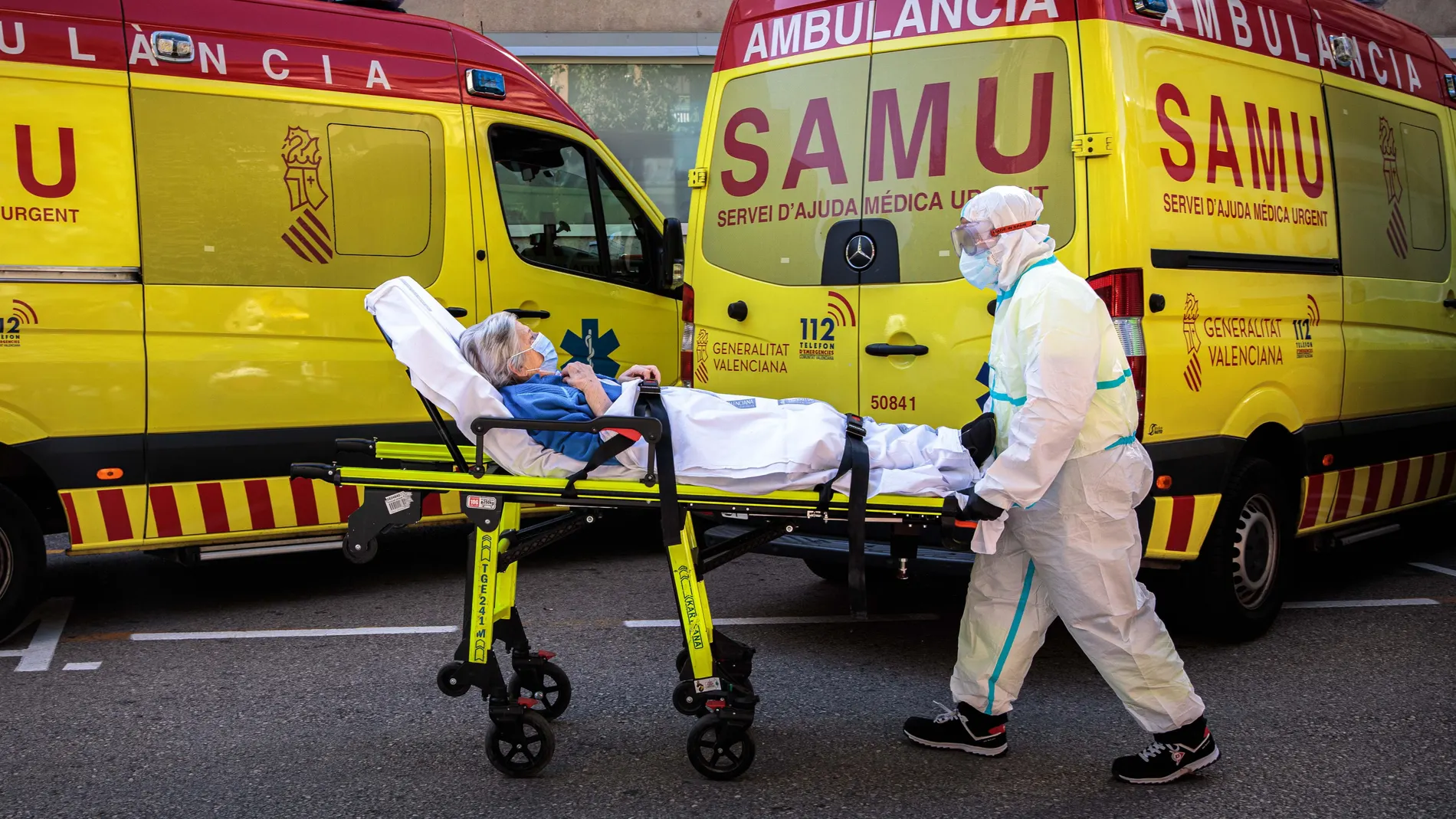 Un sanitaris con equipo de protección especial para evitar contagios de coronavirus traslada a un paciente de una ambulancia a urgencias del Hospital Clínico de València.