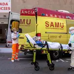 Un sanitarios con equipo de protección especial para evitar contagios de coronavirus, traslada a un paciente de una ambulancia a urgencias del Hospital Clínico de València