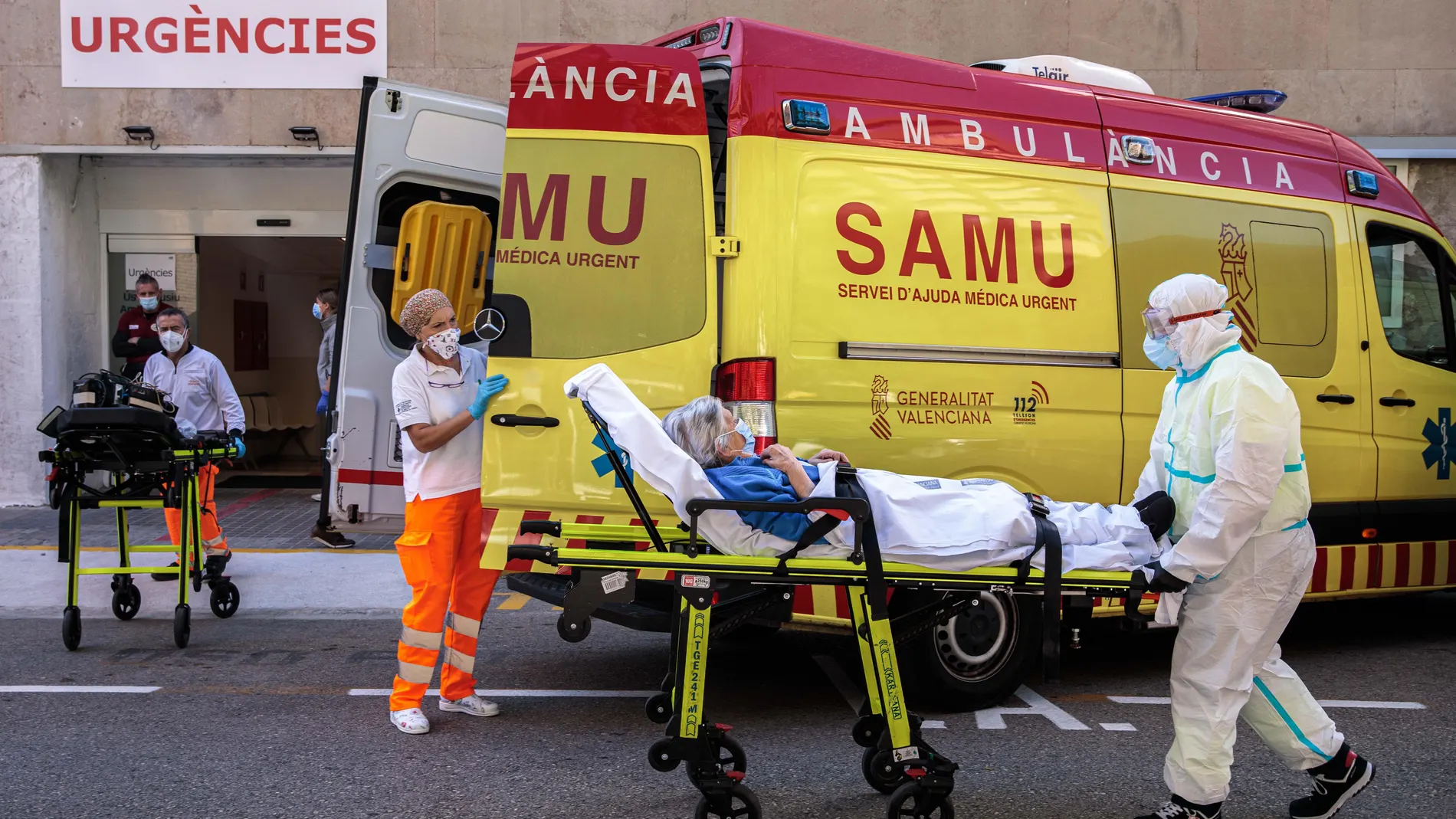 Un sanitarios con equipo de protección especial para evitar contagios de coronavirus, traslada a un paciente de una ambulancia a urgencias del Hospital Clínico de València