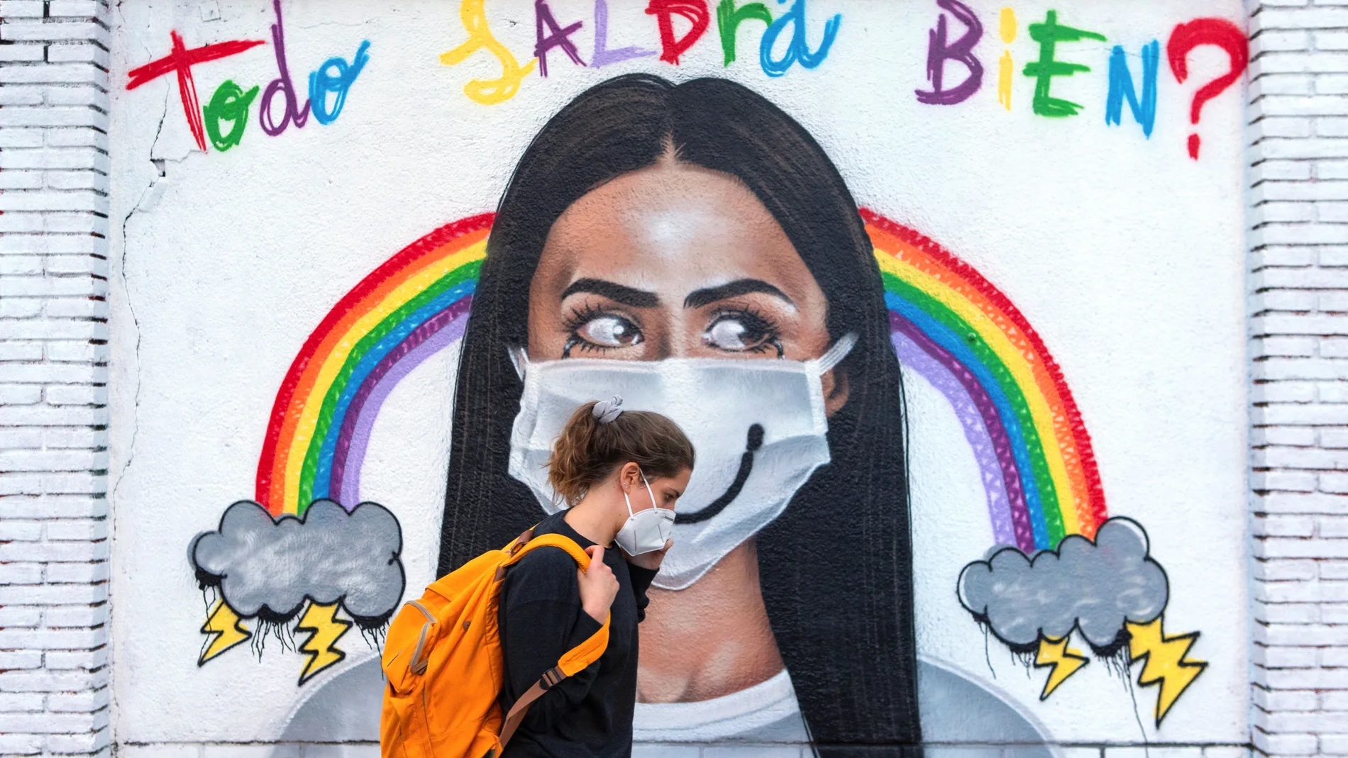 Una mujer pasea frente a un mural este martes en Barcelona, horas antes del toque de queda decretado por el Gobierno de la Generalitat. La Generalitat, que adelantó el toque de queda a las 22.00 horas, ha puesto sobre la mesa la posibilidad de decretar confinamientos domiciliarios durante los fines de semana. Con el sector de la restauración clausurado desde mediados de mes, los comercios deben cerrar a las 21 horas y teatros, cines y auditorios, a las 22. EFE/Enric Fontcuberta