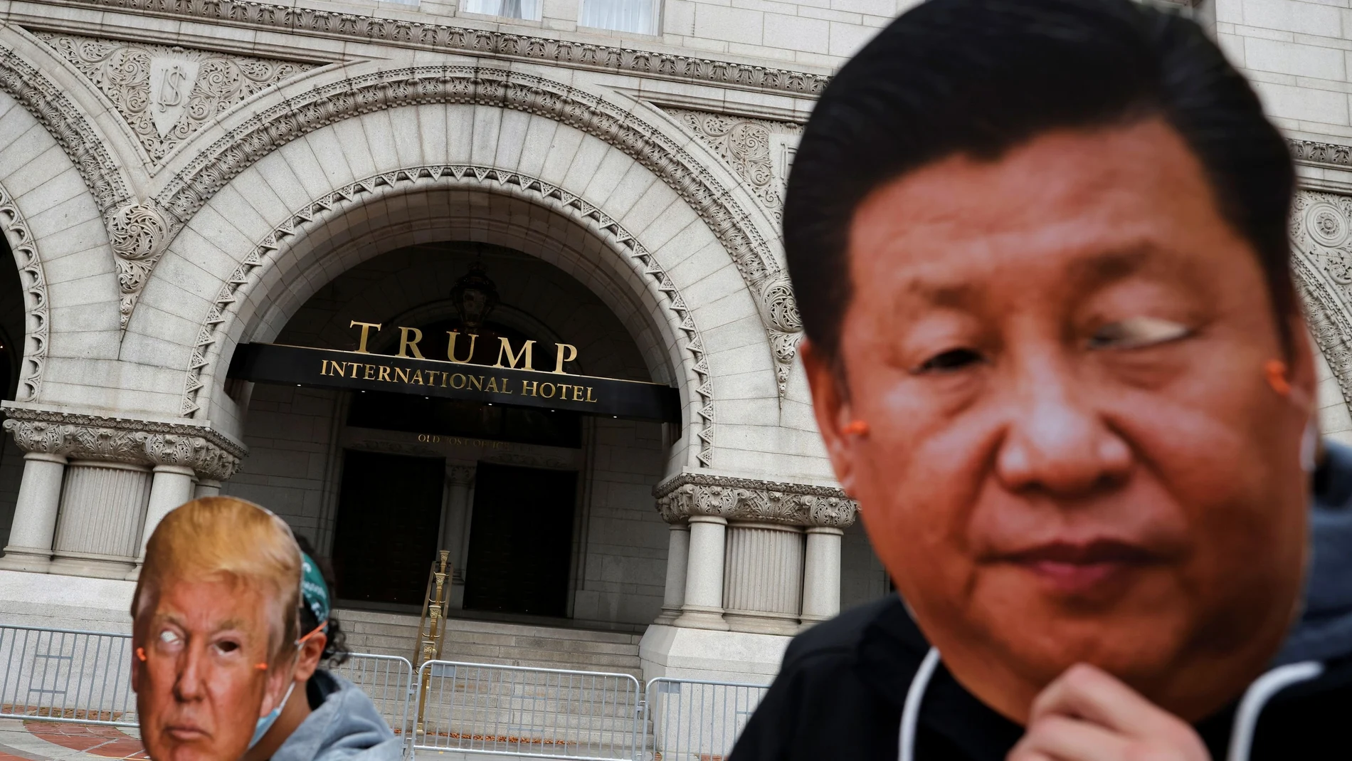 Manifestantes con máscaras de Trump y Xi Jinping