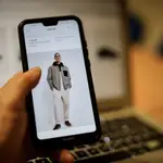 Una persona observa en su móvil artículos de moda en la página de un comercio online